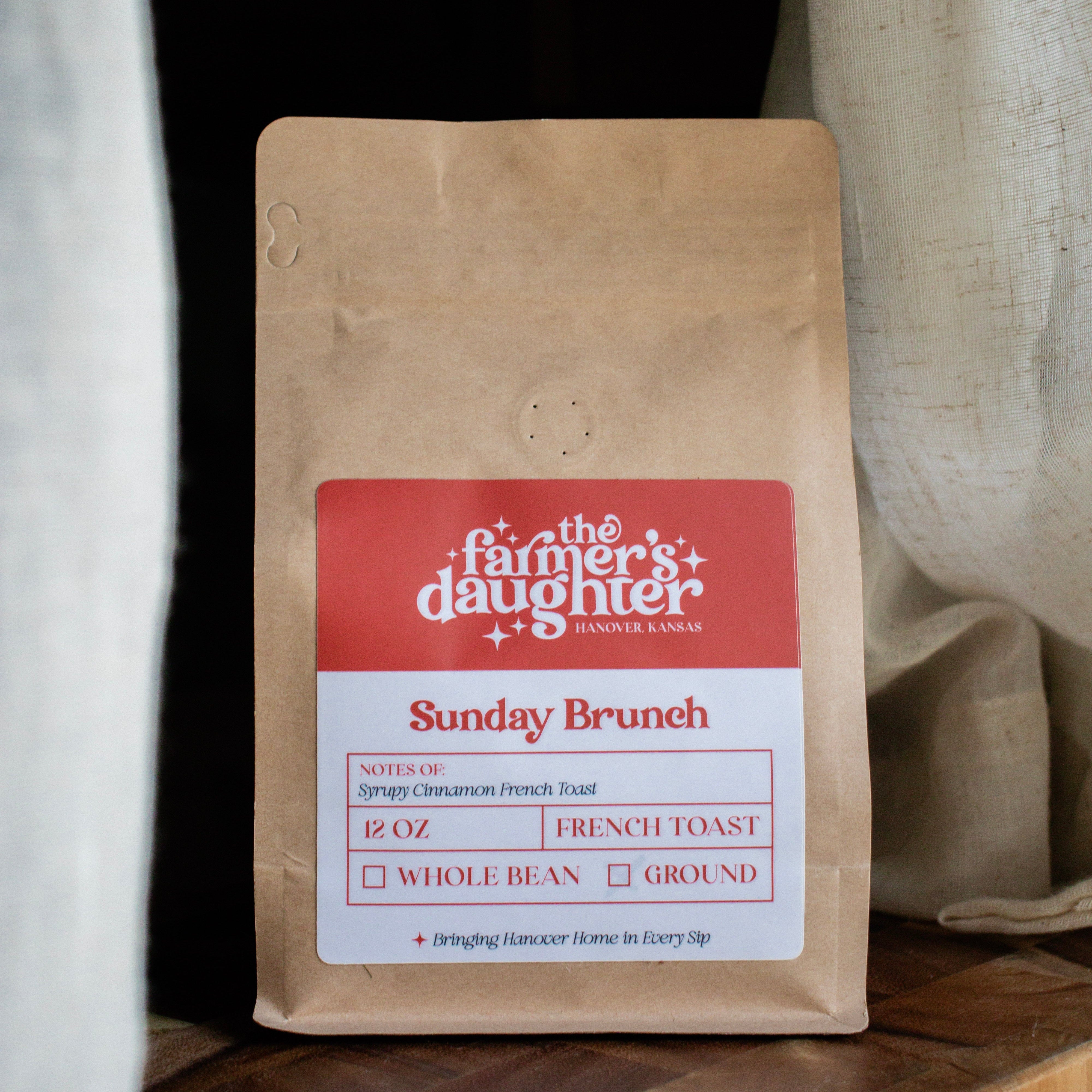 Coffee bag labeled 'The Farmer's Daughter' on a wooden surface with a neutral background